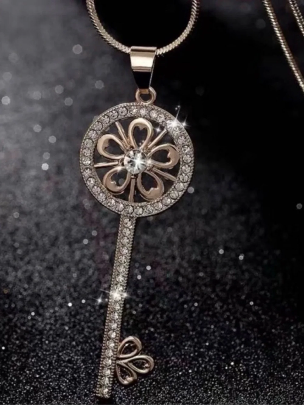 silvery crystal-encrusted key pendant necklace floral detail delicate long chain
